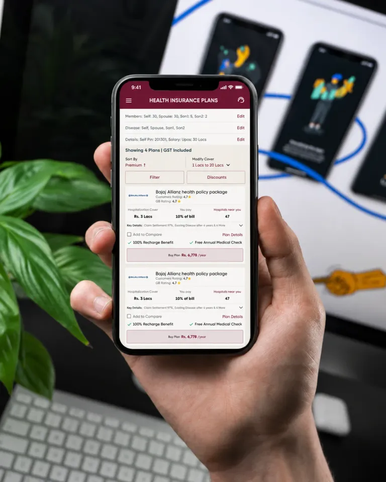 A hand holding a phone that shows GroupBima’s Health Insurance Plans screen: sort and filter controls, and policy cards with the cover, the share of the bill you pay, hospitals nearby and a Buy Plan button