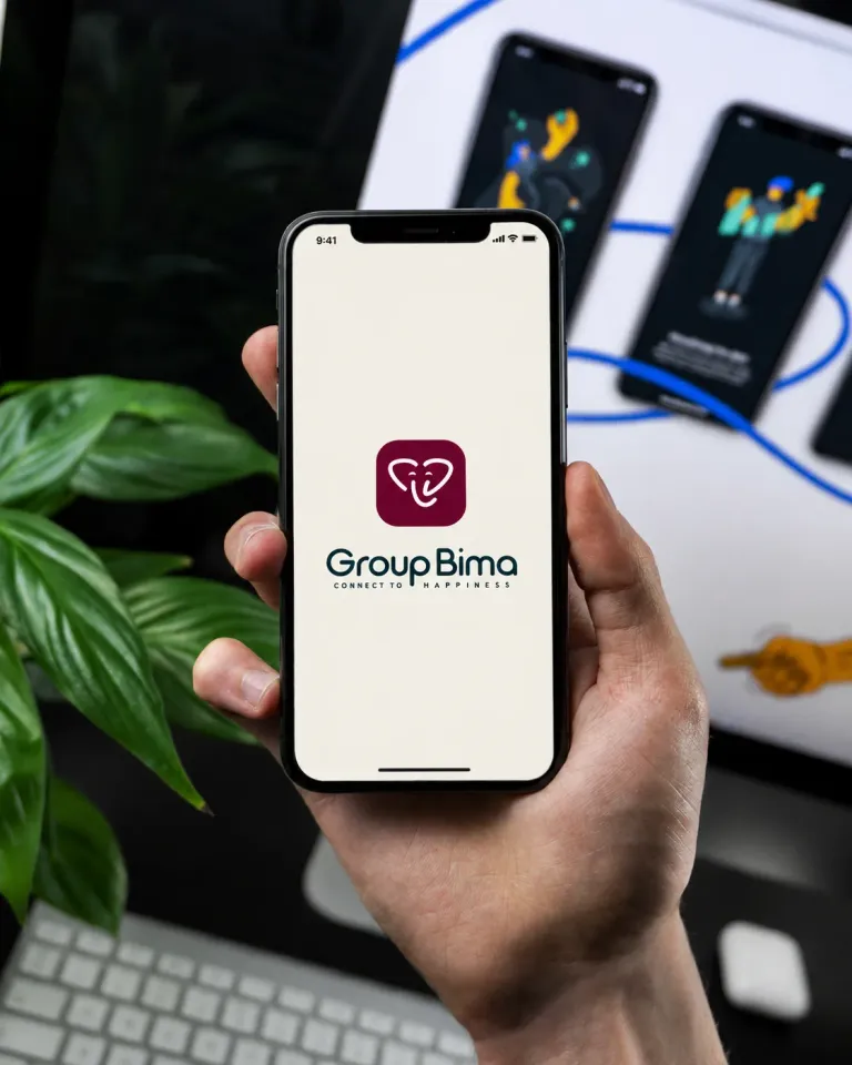 A hand holding a phone that shows GroupBima’s splash screen: the crimson elephant mark, the GroupBima wordmark and the line “Connect to happiness”